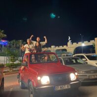 Fünf Personen posieren in einem roten Suzuki Santana mit einem türkischen Kennzeichen.